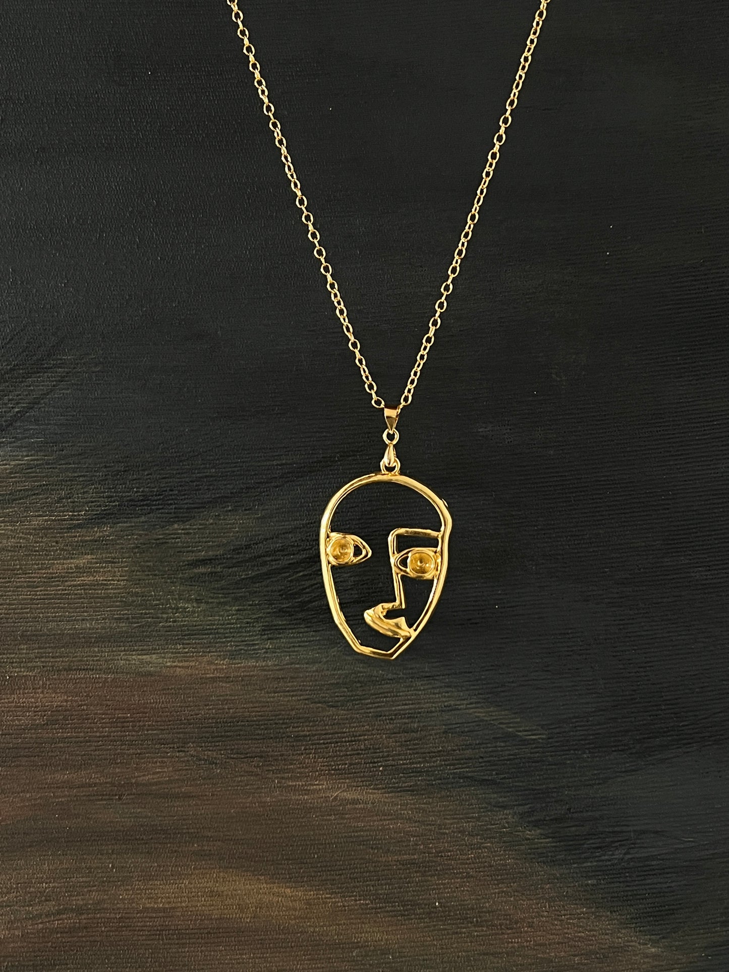 Golden face necklace